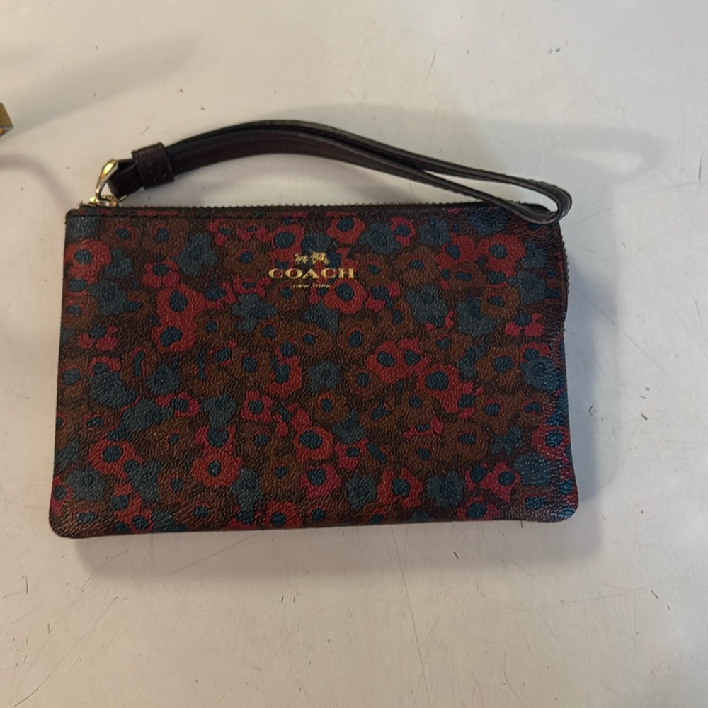 Coach wristlet used once. Multi color brown burgundy and blue flower design.